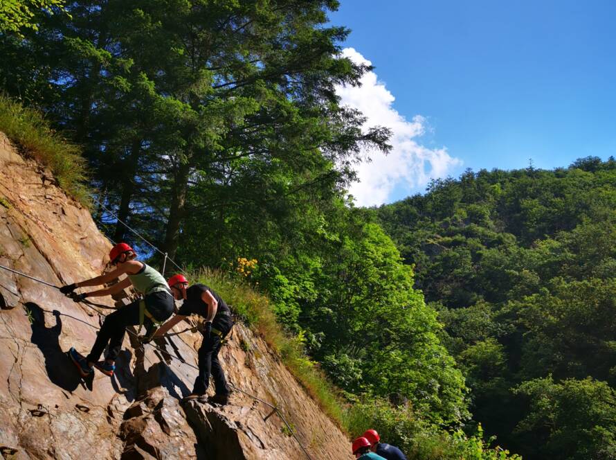 Klettergruppe zeigen am Übungsklettersteig des Manderscheider Burgenklettersteigs, was sie beim Einsteiger-Kletterkurs gelent haben.